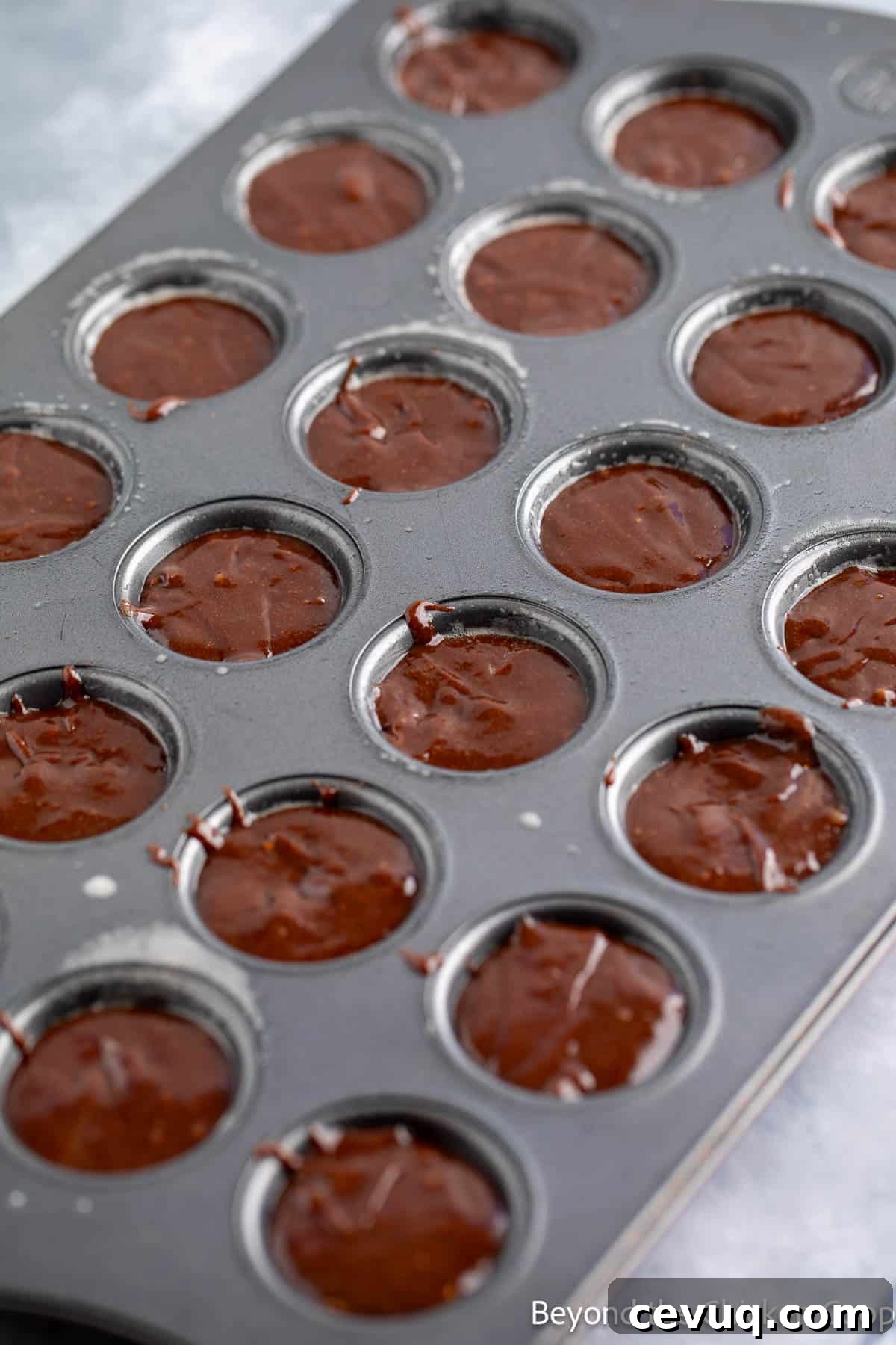 Brownie batter in a mini muffin tin.
