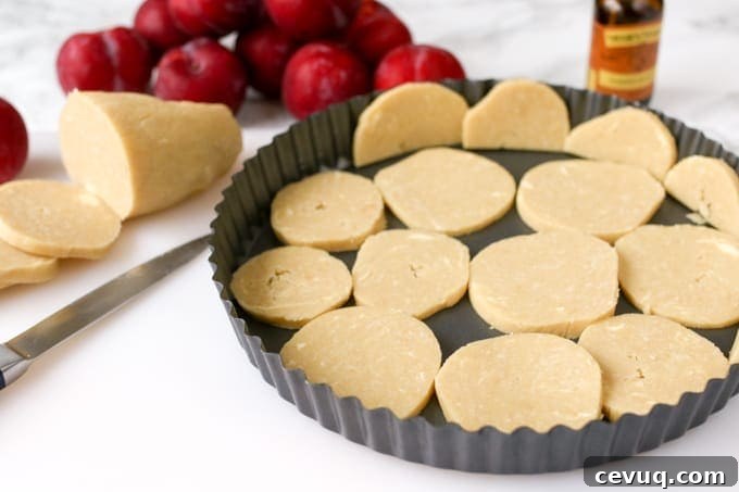 A fruit plum tart with almond frangipane and crumbly sweet pastry.