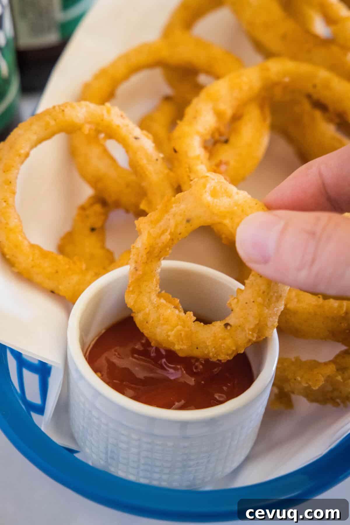 onion ring being dipped in ketchup