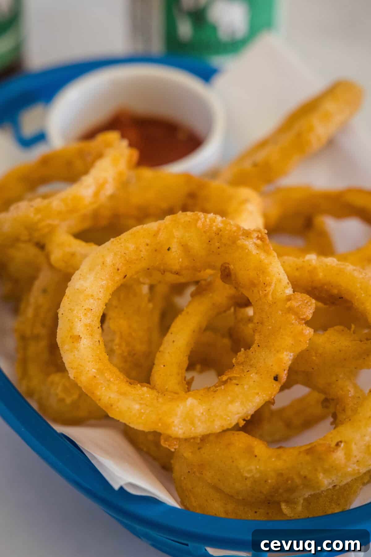 onion rings in a basket with ketchup