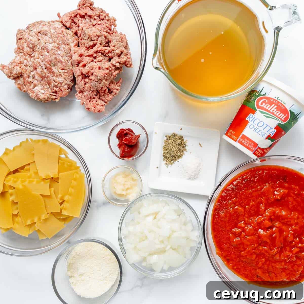 Various lasagna soup ingredients arranged in bowls, including ground meat, broken pasta, onions, tomato sauce, broth, ricotta cheese, parmesan, tomato paste, garlic, and seasonings.