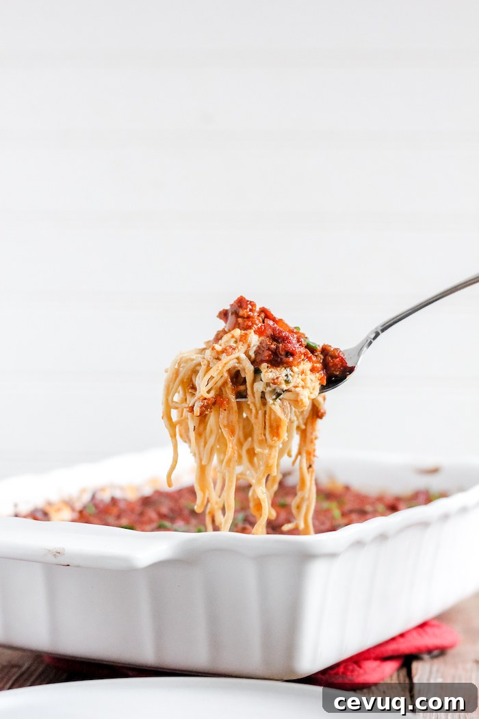 Image shows a forkful of spaghetti over a casserole dish