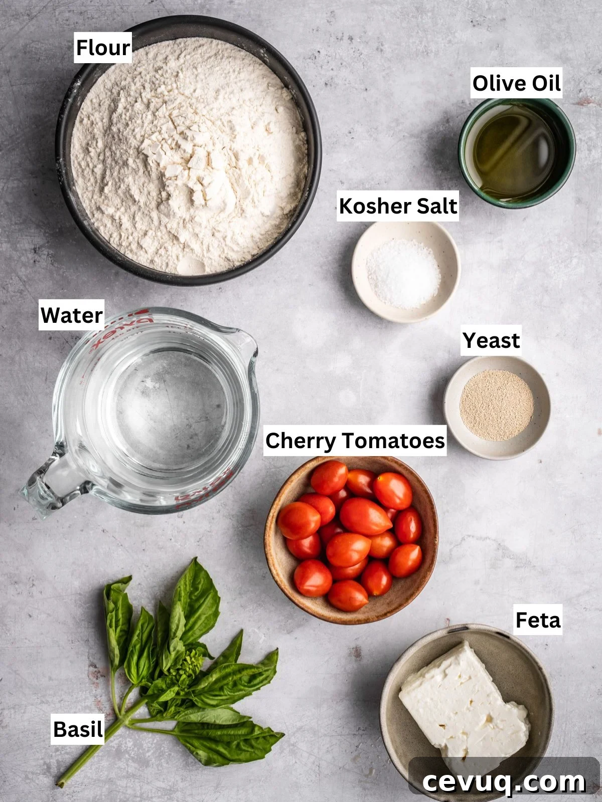 Feta and cherry tomato focaccia recipe ingredients with individual labels on a board.