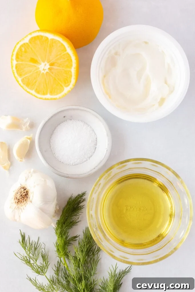 Top down shot of ingredients for a Greek yogurt marinade in small bowls, including yogurt, kosher salt, oil, garlic, fresh dill, and a cut lemon.