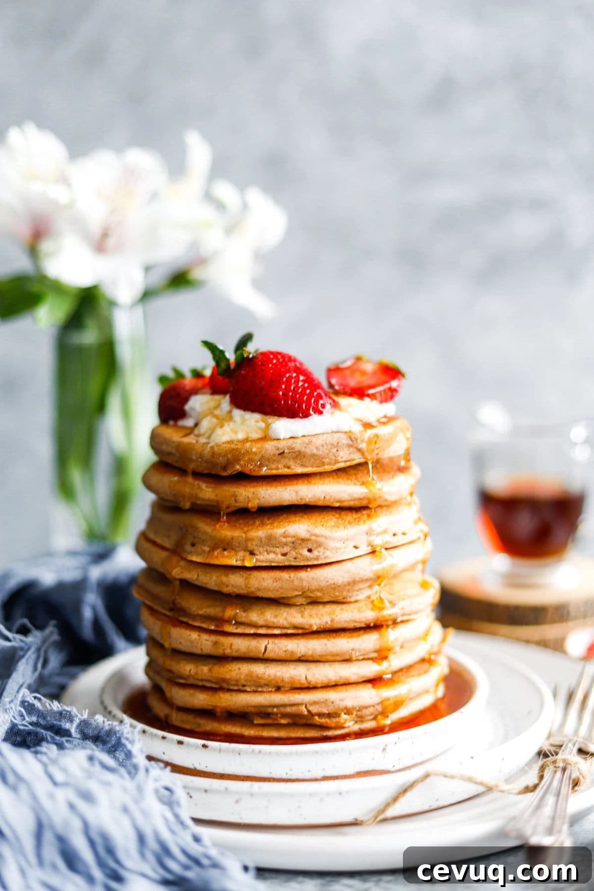 A stack of homemade pancakes with a strawberry on top.