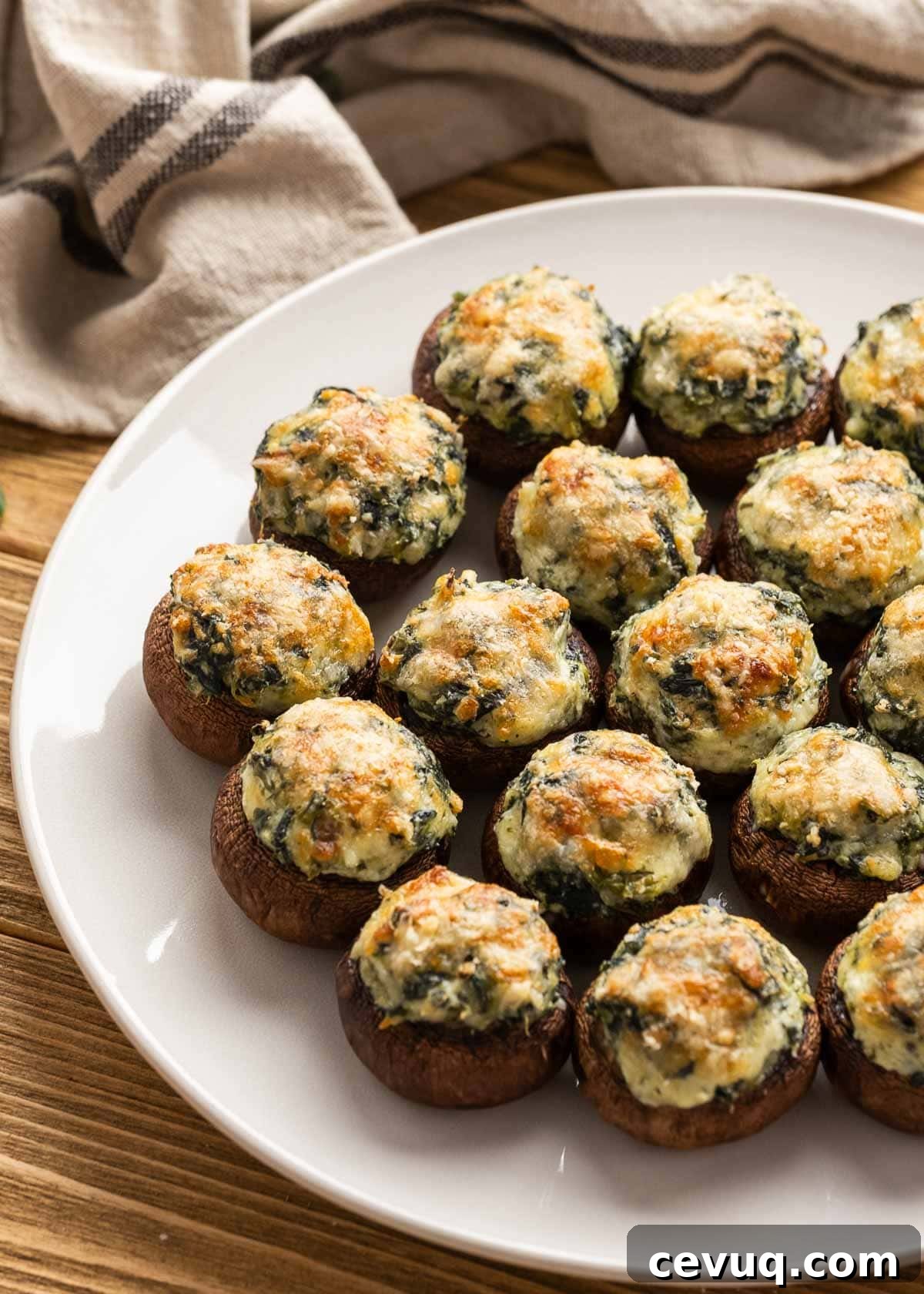 a few servings of spinach stuffed mushrooms on a white plate