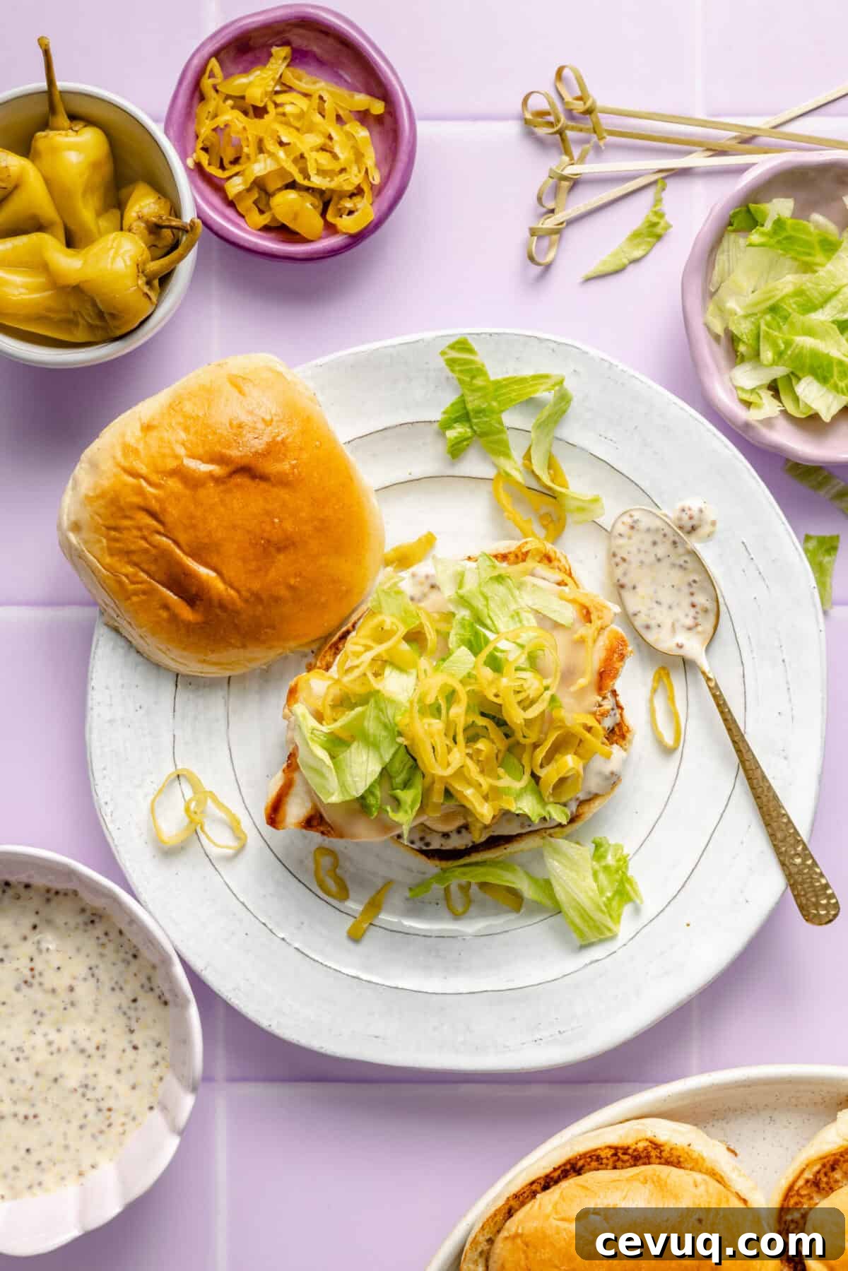 Pepperoncini Grilled Chicken Sandwich getting assembled on plate.