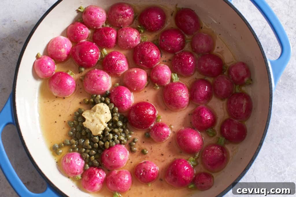 Cooked radish halves in an enamel pan with capers and dijon mustard.