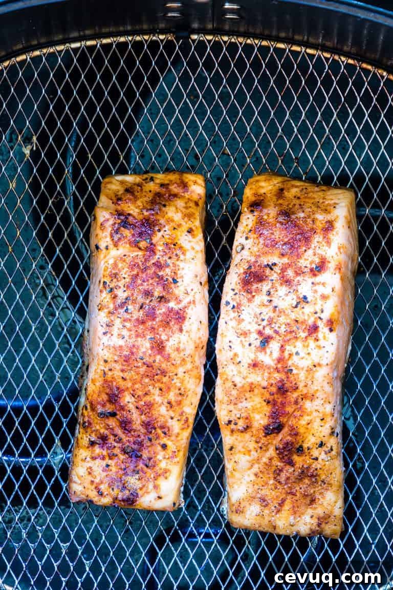 Two cooked Air Fryer Salmon fillets inside the air fryer basket
