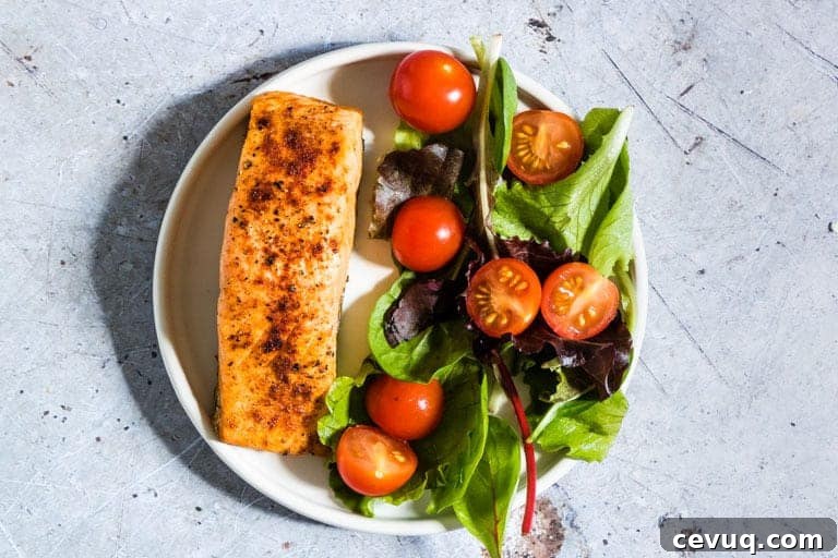 Air Fryer Salmon served with a green salad on a white plate