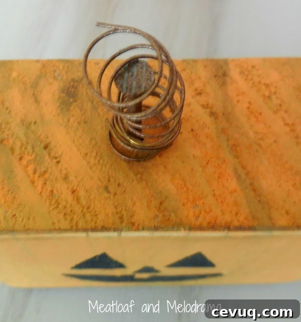 spray paint nails and wire with bronze spray paint and nail on wood pumpkin