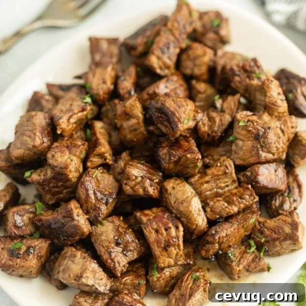 Blackstone Grill Garlic Bread Recipe: Crispy Grilled Loaf 9 Grilled Steak Bites stacked on a platter.