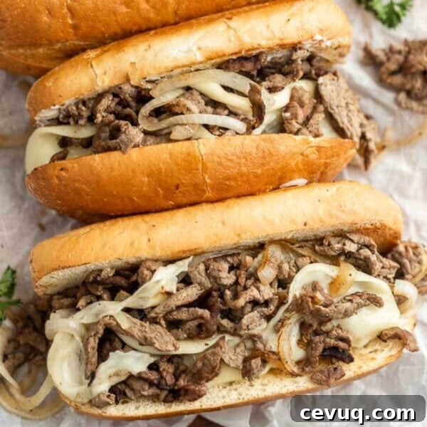 Blackstone Grill Garlic Bread Recipe: Crispy Grilled Loaf 10 Two sandwiches with meat and onions on paper.