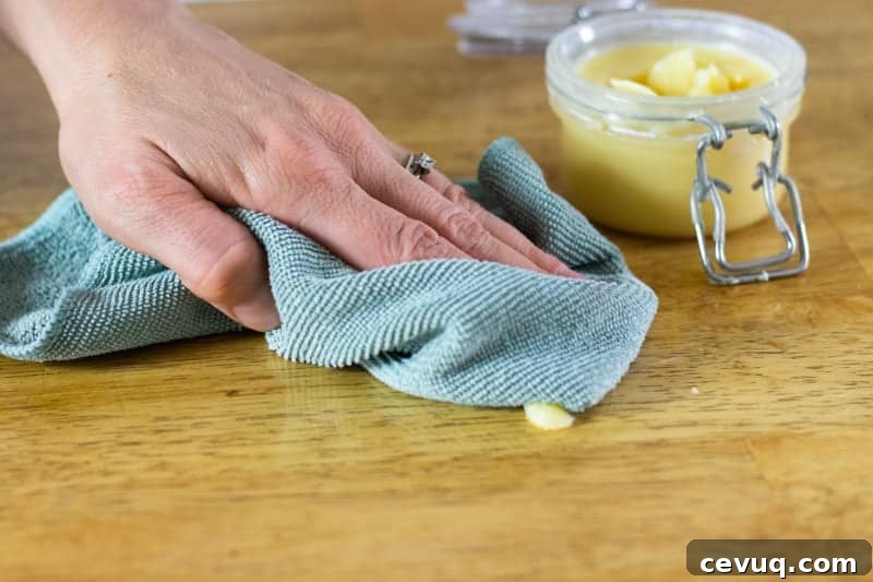 working in beeswax wood polish with a green microfiber cloth