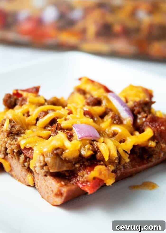 Homemade Chili Seasoning Mix for Authentic, Bold Flavor 5 piece of keto chili dog casserole on a white plate with casserole dish in background