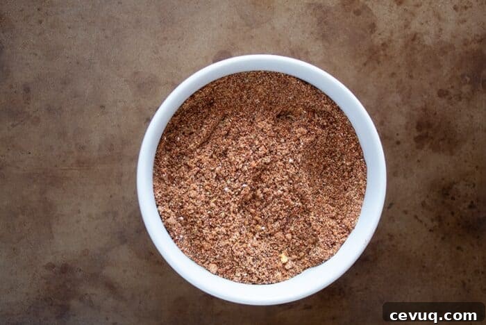 Homemade Chili Seasoning Mix for Authentic, Bold Flavor 8 keto taco seasoning in a white bowl on a distressed serving tray