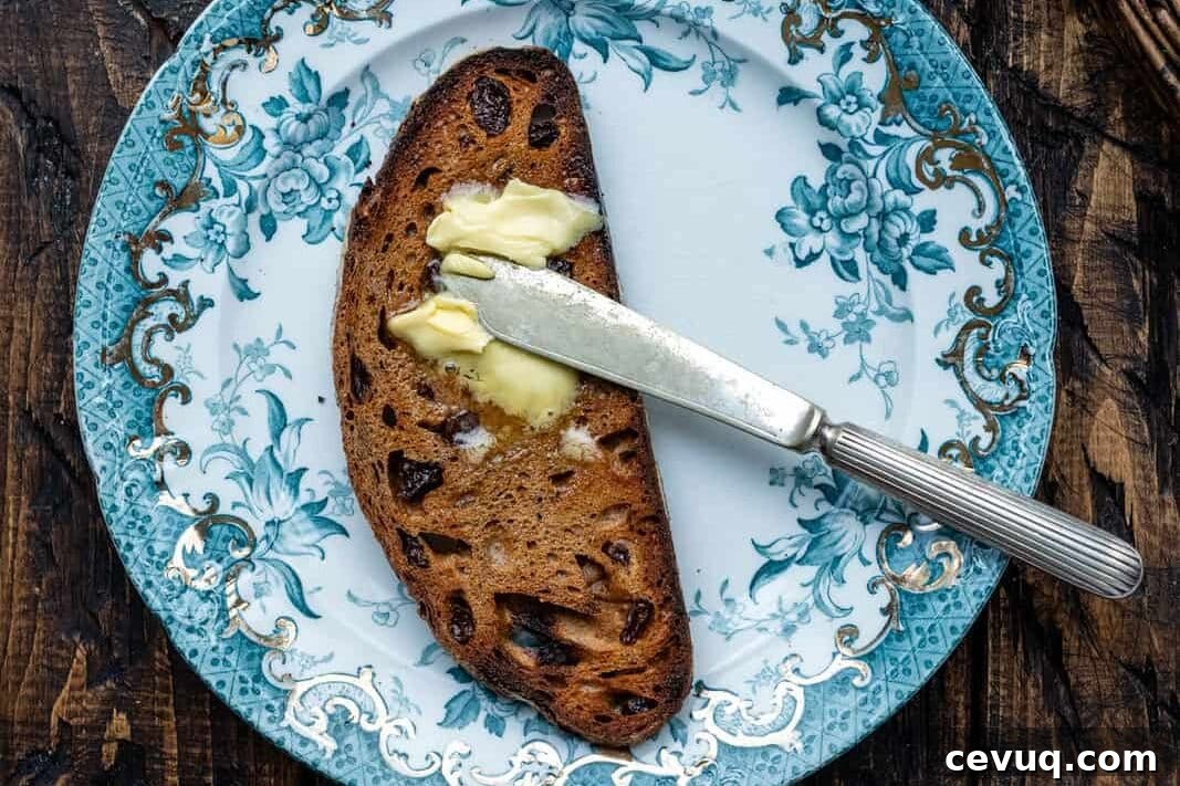 Cinnamon Raisin Sourdough Loaf Recipe 4 Slice of sourdough cinnamon raisin bread spread with butter on a vintage plate