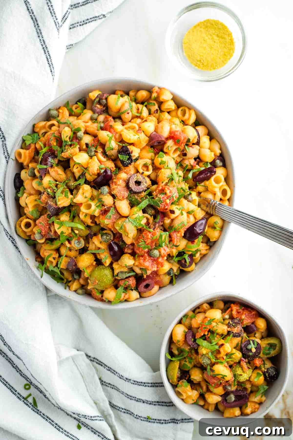 Vegan White Bean Puttanesca Pasta 2 One large and one small bowl of puttanesca pasta with white beans, olives and capers.