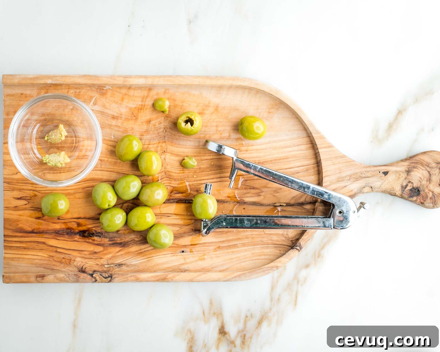 Vegan White Bean Puttanesca Pasta 4 Olive pitter, pulling out the pits from castelvetrano olives.