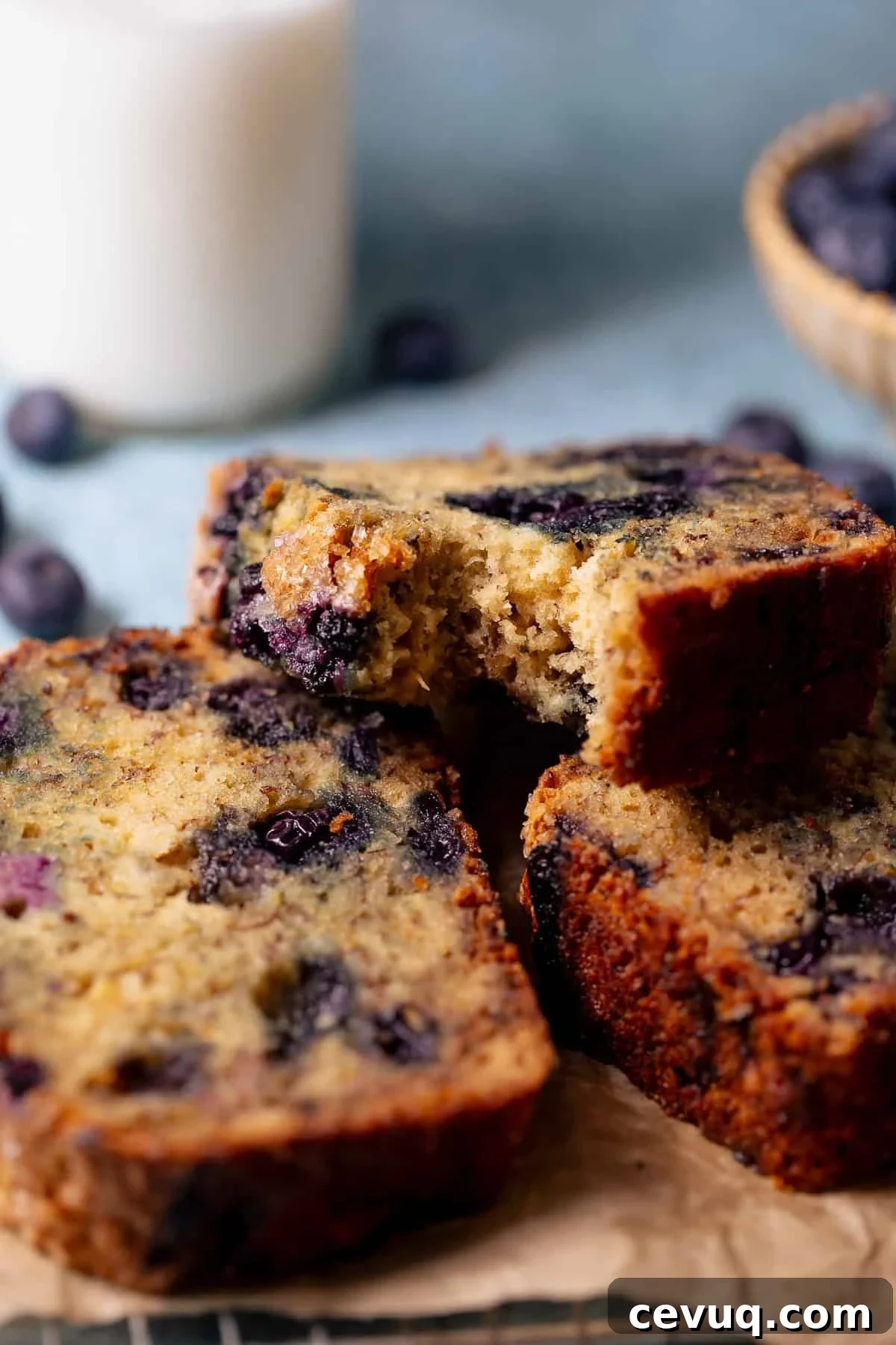 Close-up of a slice of blueberry banana bread showing a moist, tender crumb.
