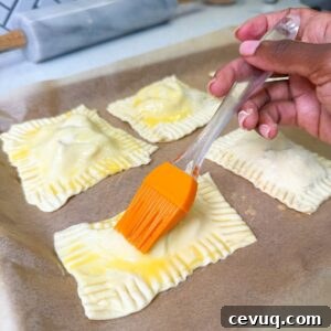 Flaky Apple Hand Pies with Puff Pastry 10 Egg wash being brushed on apple hand pies.