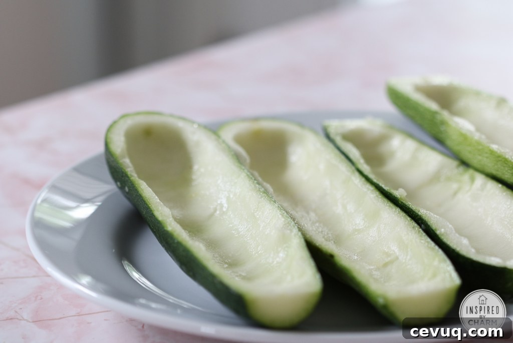 hallowed out zucchini halves on a plate.