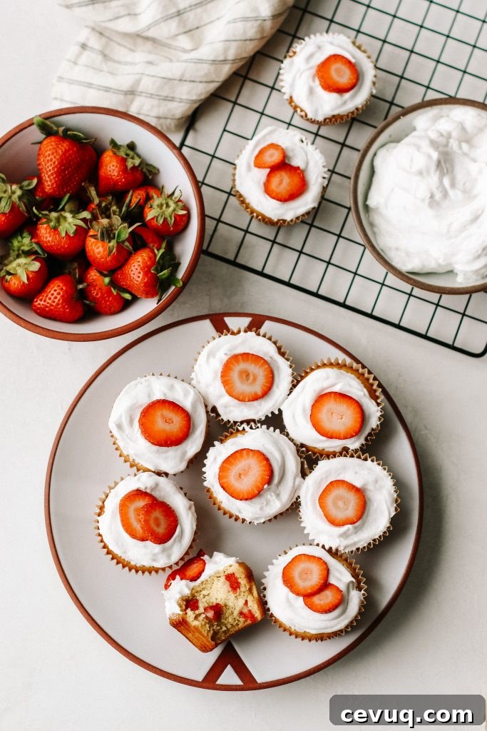 Paleo Strawberry Shortcake Cupcakes Recipe 3 strawberry shortcake cupcakes on a plate with a cooling rack bowl of strawberries and bowl of cool whip