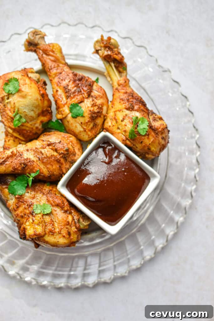 Tender, Juicy Instant Pot Chicken Drumsticks Recipe 2 The Instant Pot Chicken Legs are on a glass plate with a bowl of barbecue sauce.
