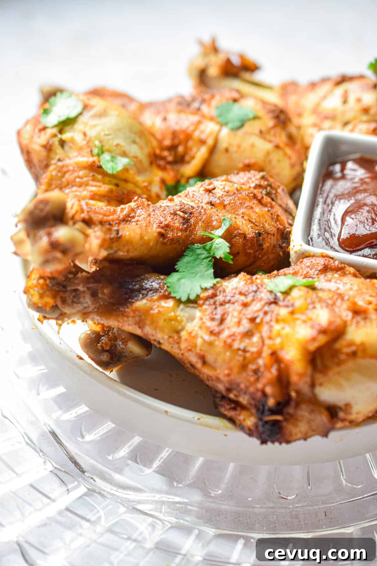 Tender, Juicy Instant Pot Chicken Drumsticks Recipe 10 The Instant Pot Chicken Legs are on a glass plate all laid on top of each other.
