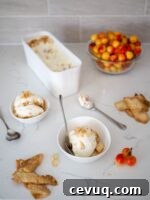 A bowl of cherry pie ice cream in the middle of a counter covered in cherries, pie crusts, and ice cream.