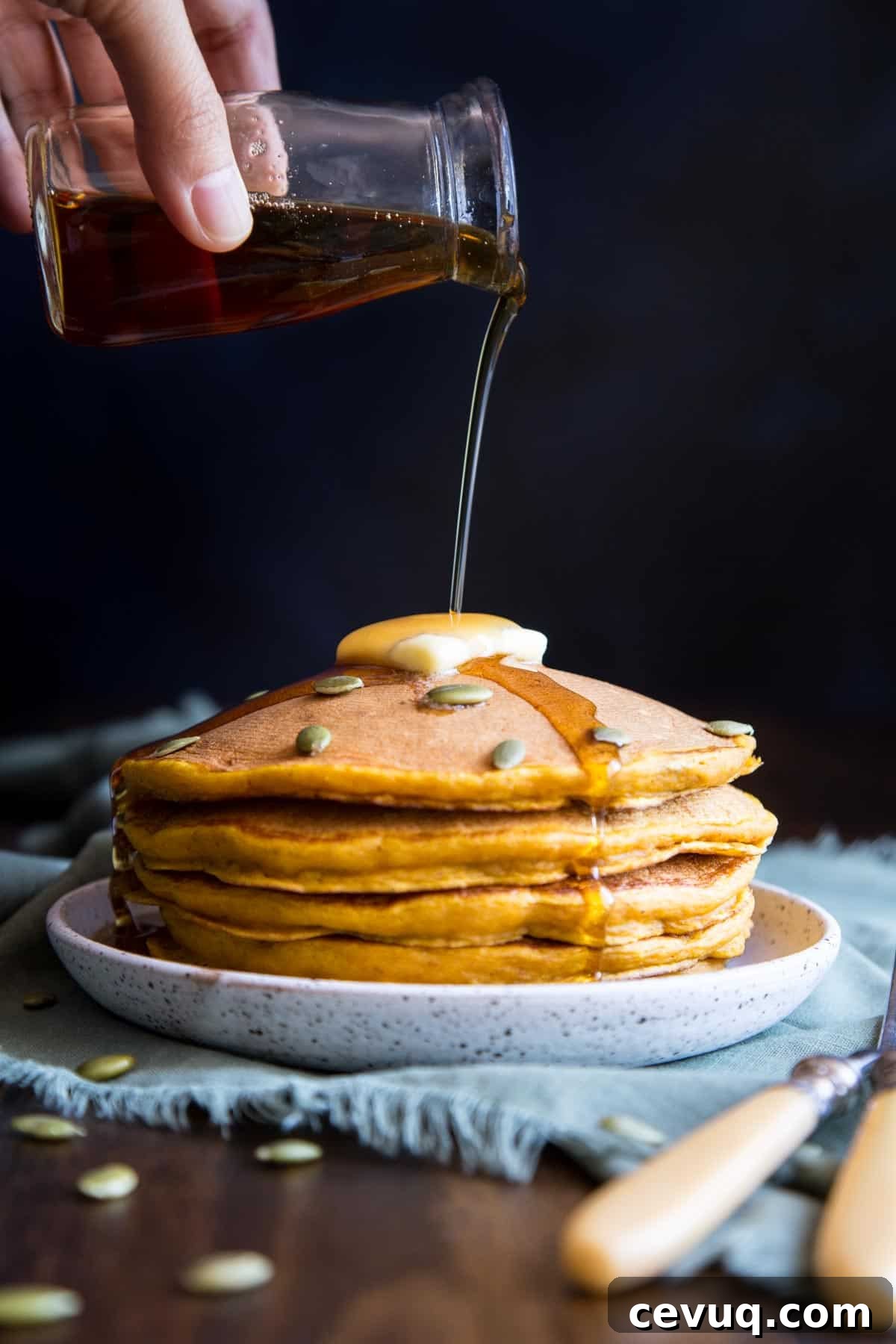Fluffy Buttermilk Pumpkin Spice Pancakes 9 Pouring maple syrup on a stack of buttermilk pumpkin pancakes.