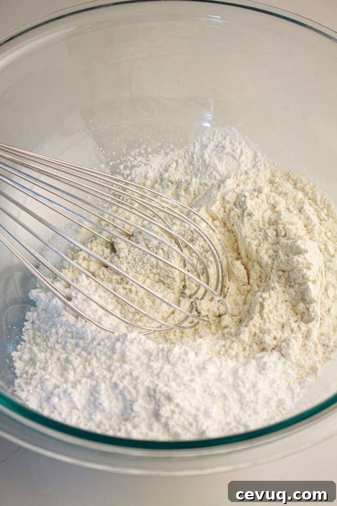 Dry ingredients being whisked in a glass bowl.