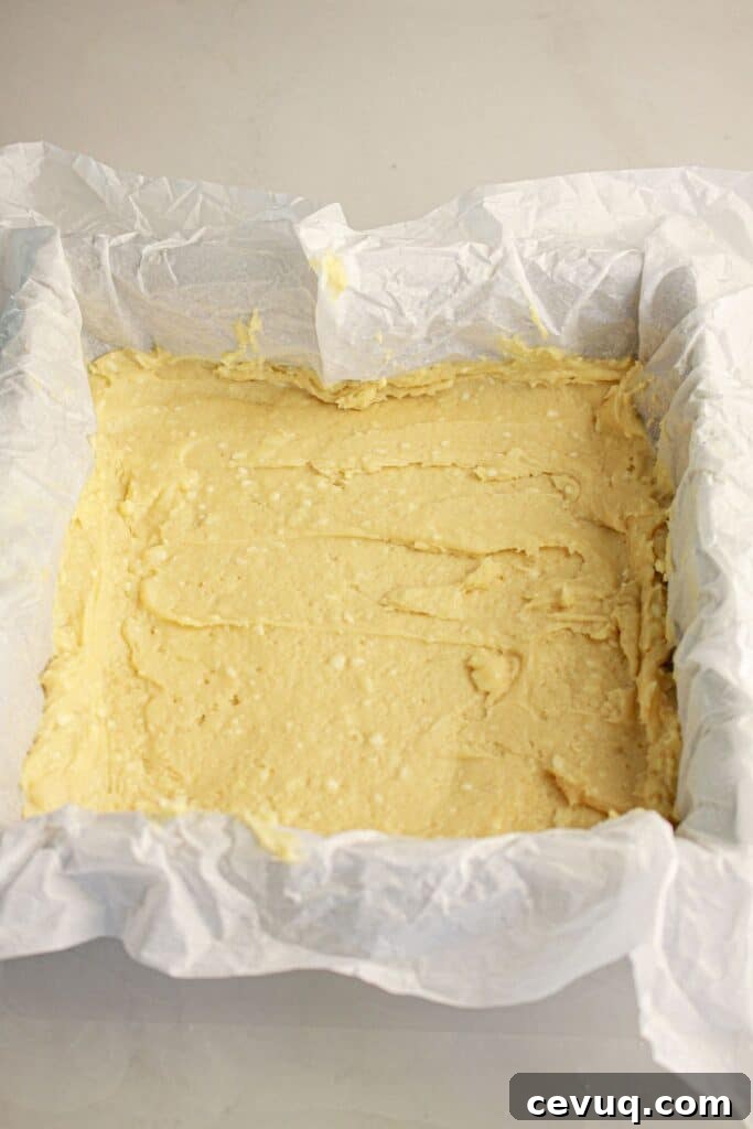 Batter being spread in a baking pan.