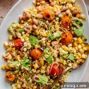 grilled corn salad with cherry tomatoes and avocado on serving platter