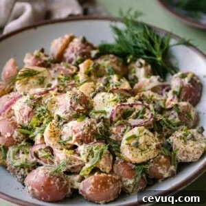 closeup photo of vegan potato salad with dill in a white bowl