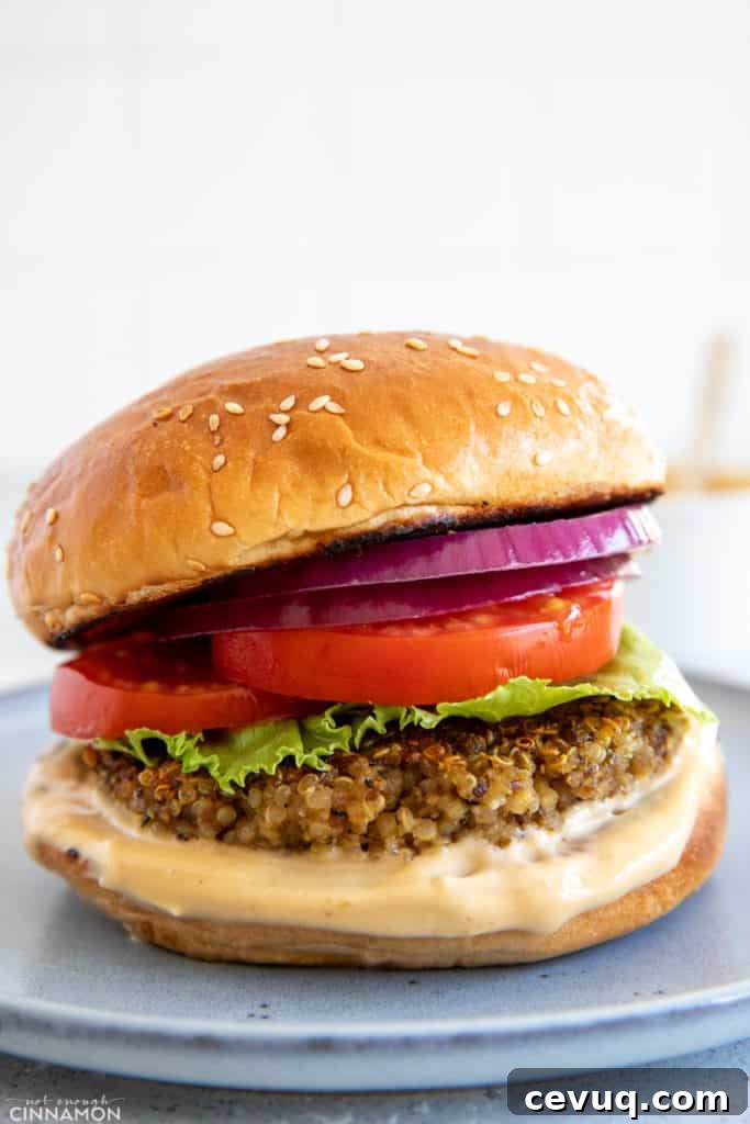 Shiitake Mushroom Quinoa Burger patty served in a burger bun with tomato onion and lettuce as well as a miso aioli 