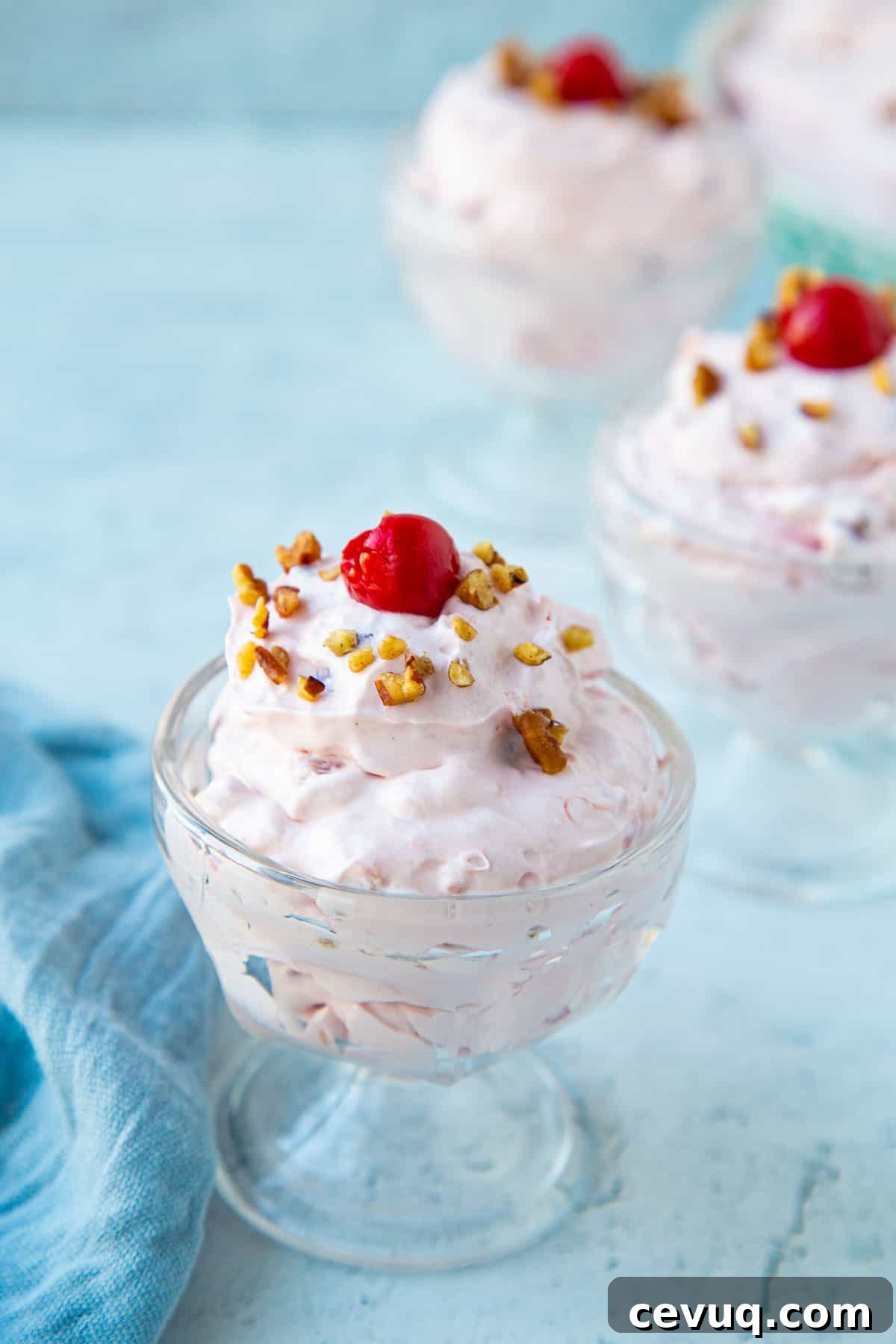 cherry salad in mini parfait dishes, topped with cherries and pecans.