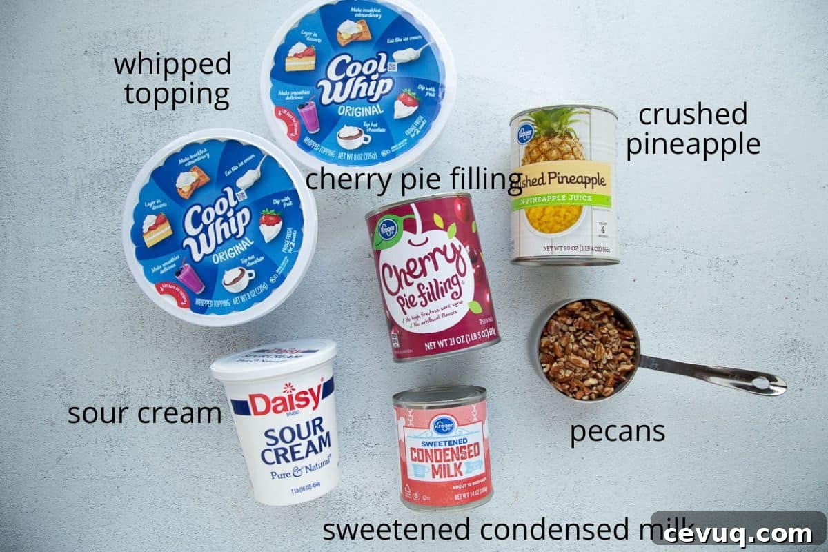 whipped topping, cherry pie filling, sour cream, and other ingredients on a white table.