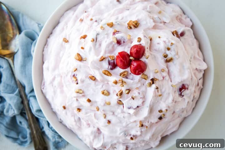 cherry salad in a large low bowl, topped with pecans and cherries.