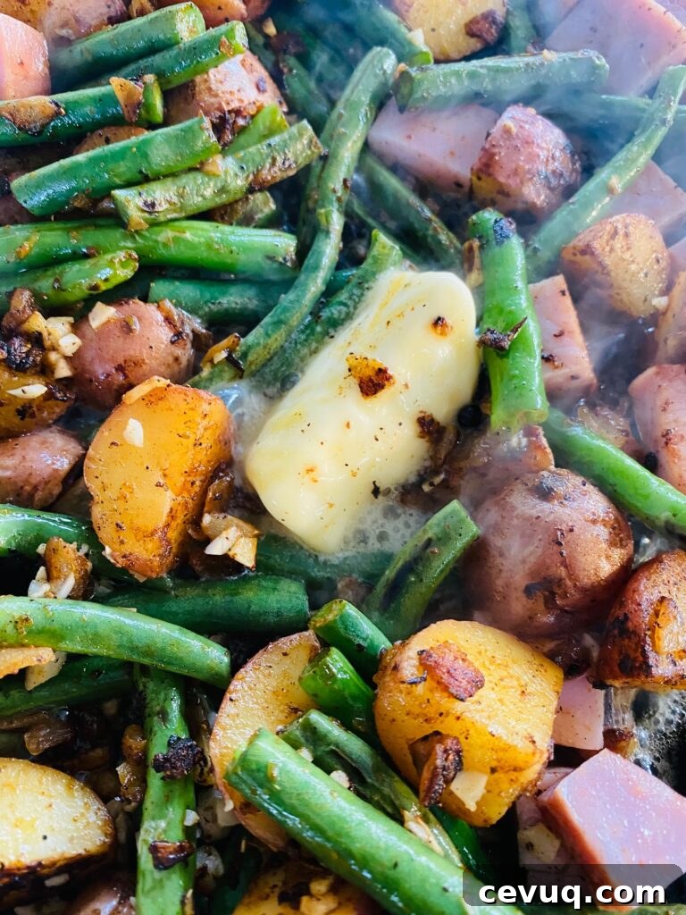 adding butter to Blackstone Ham Potatoes and Green Beans