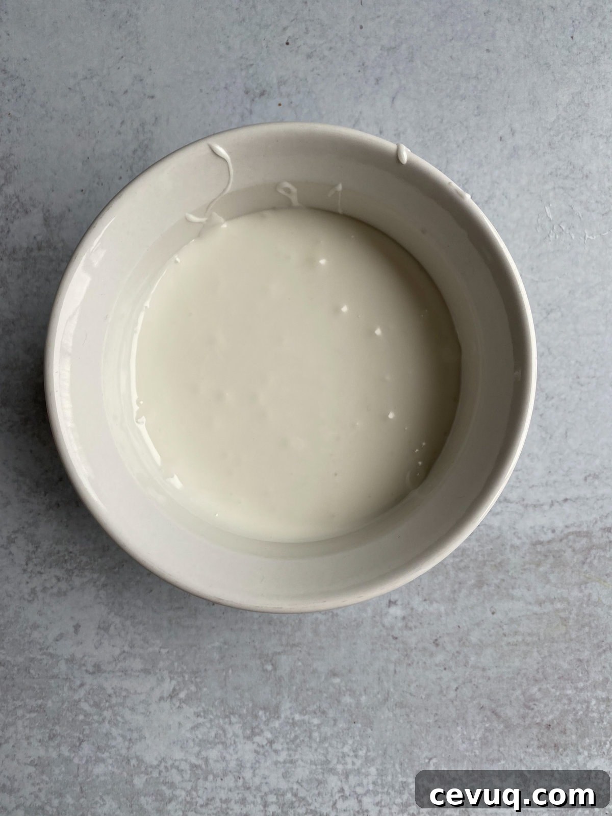 Glaze for Italian fig cookies in a bowl.