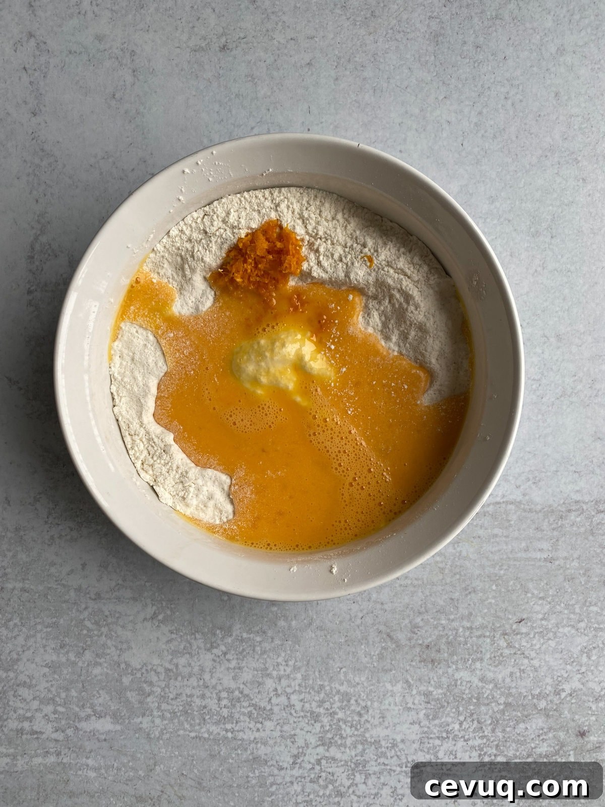 Adding the eggs and orange zest to the dry ingredients.