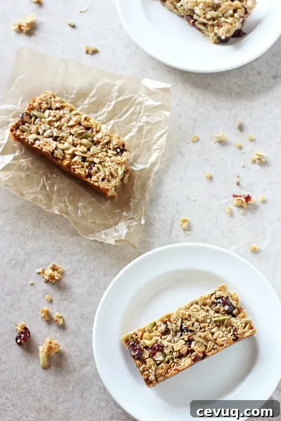 An overhead view of sliced Chewy Fruit & Nut Granola Bars on plates and wax paper.