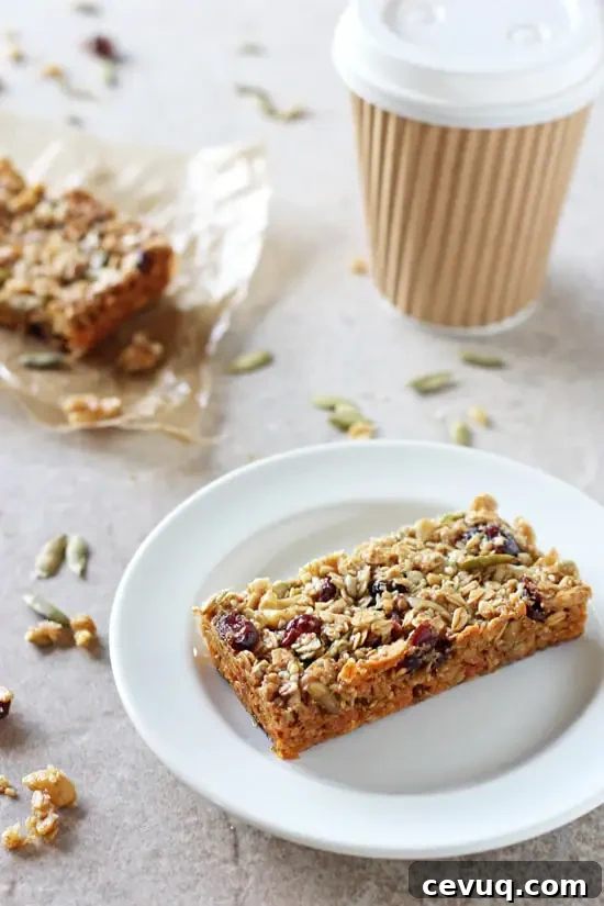 Two Chewy Fruit & Nut Granola Bars with a cup of coffee in the background.