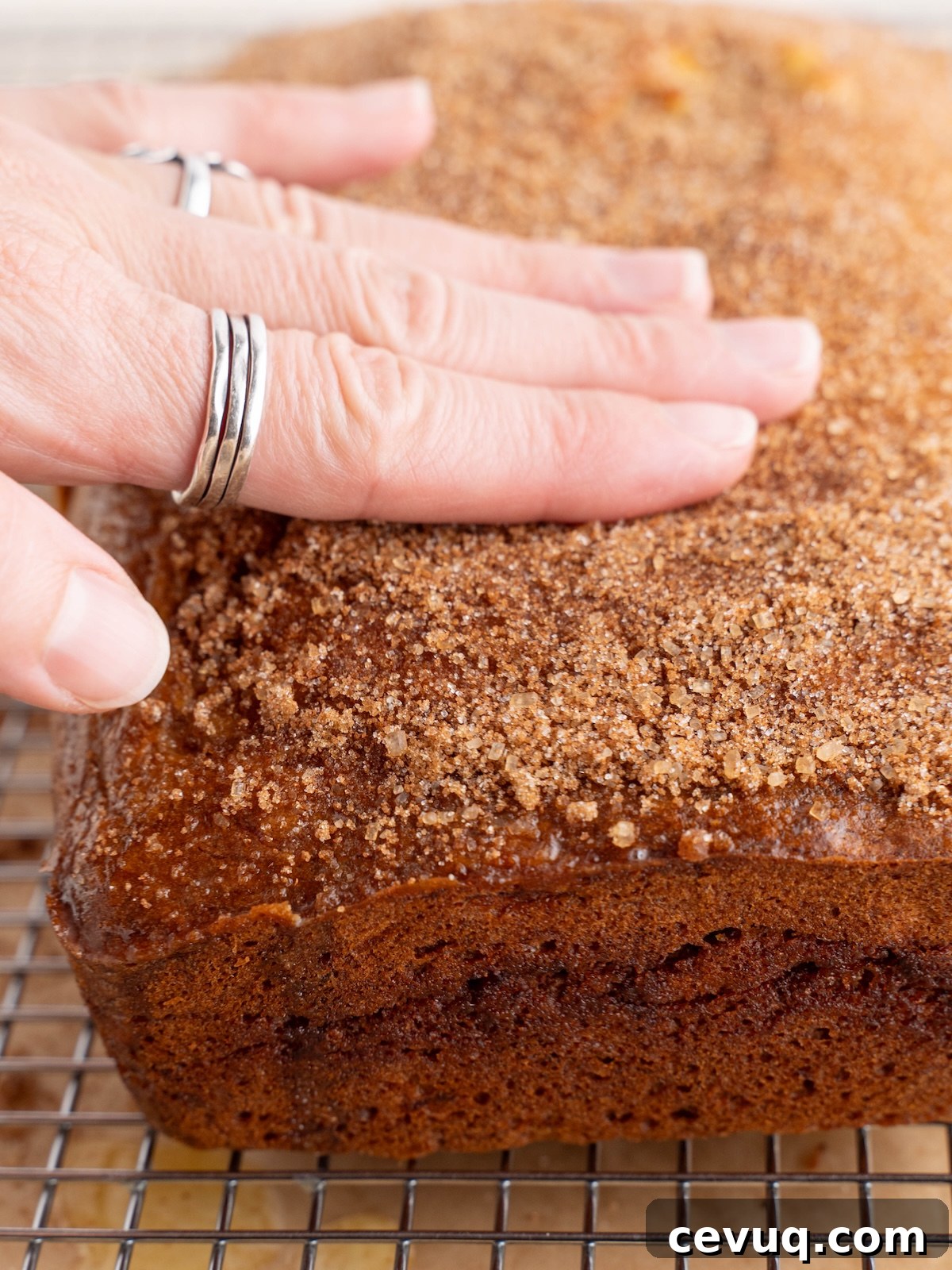 Rubbing cinnamon sugar into crust of banana bread
