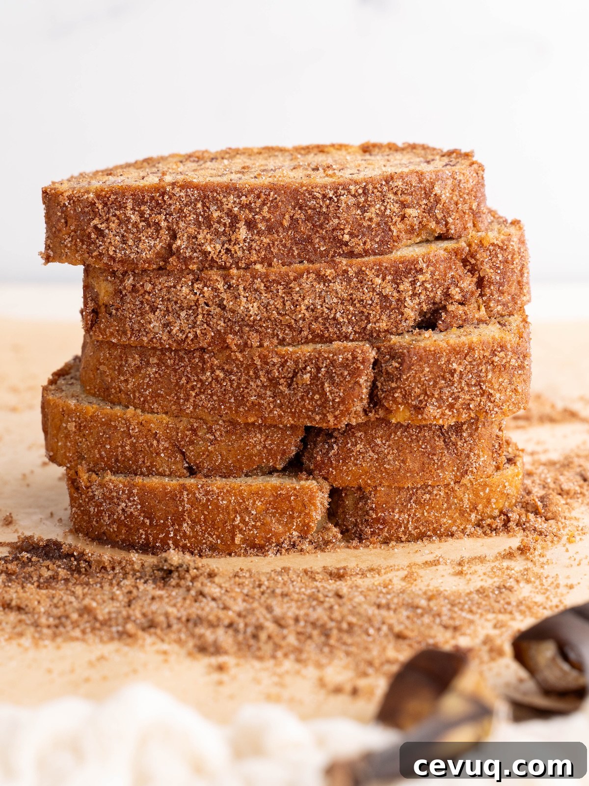 Slices of banana bread stacked to show crunchy cinnamon sugar crust