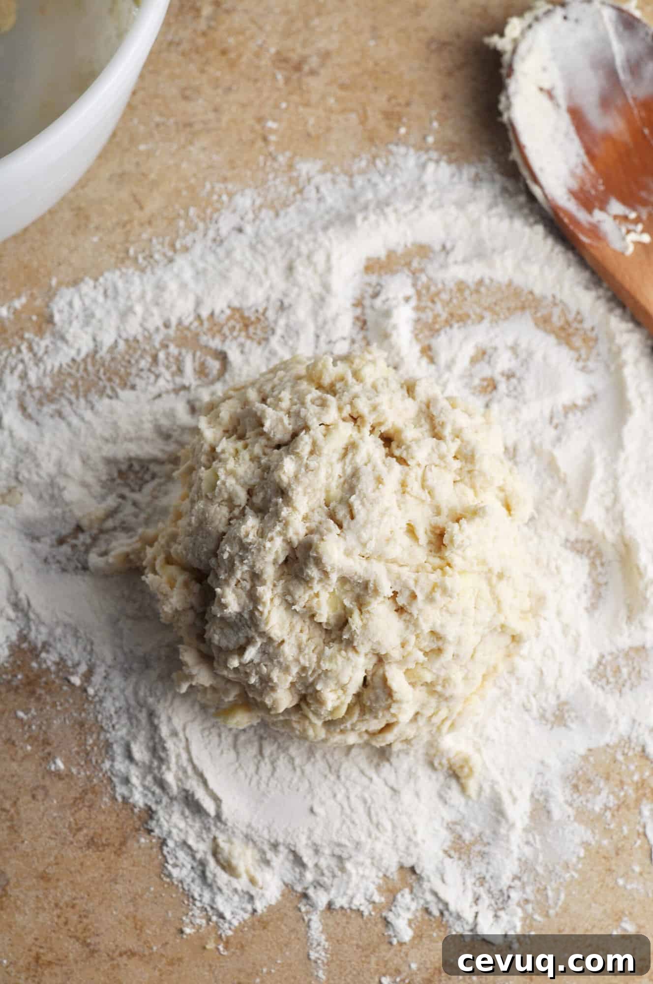 Ball of biscuit dough on floured surface.