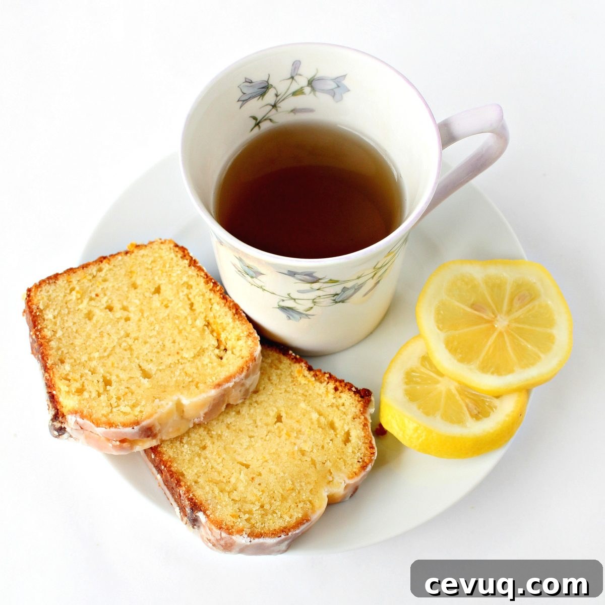 Lemon cake slices with a mug of tea and lemon slices.