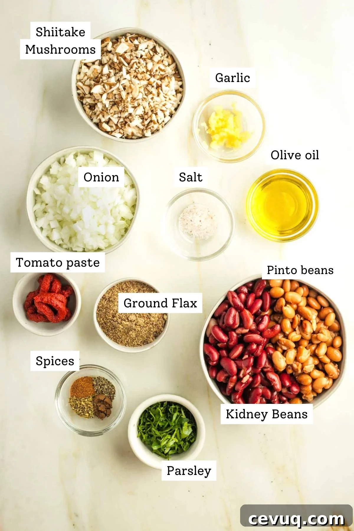 Labeled ingredients for vegan Swedish meatballs including diced mushrooms and onions, olive oil, two kinds of beans, ground flax, tomato paste, parsley and spices.