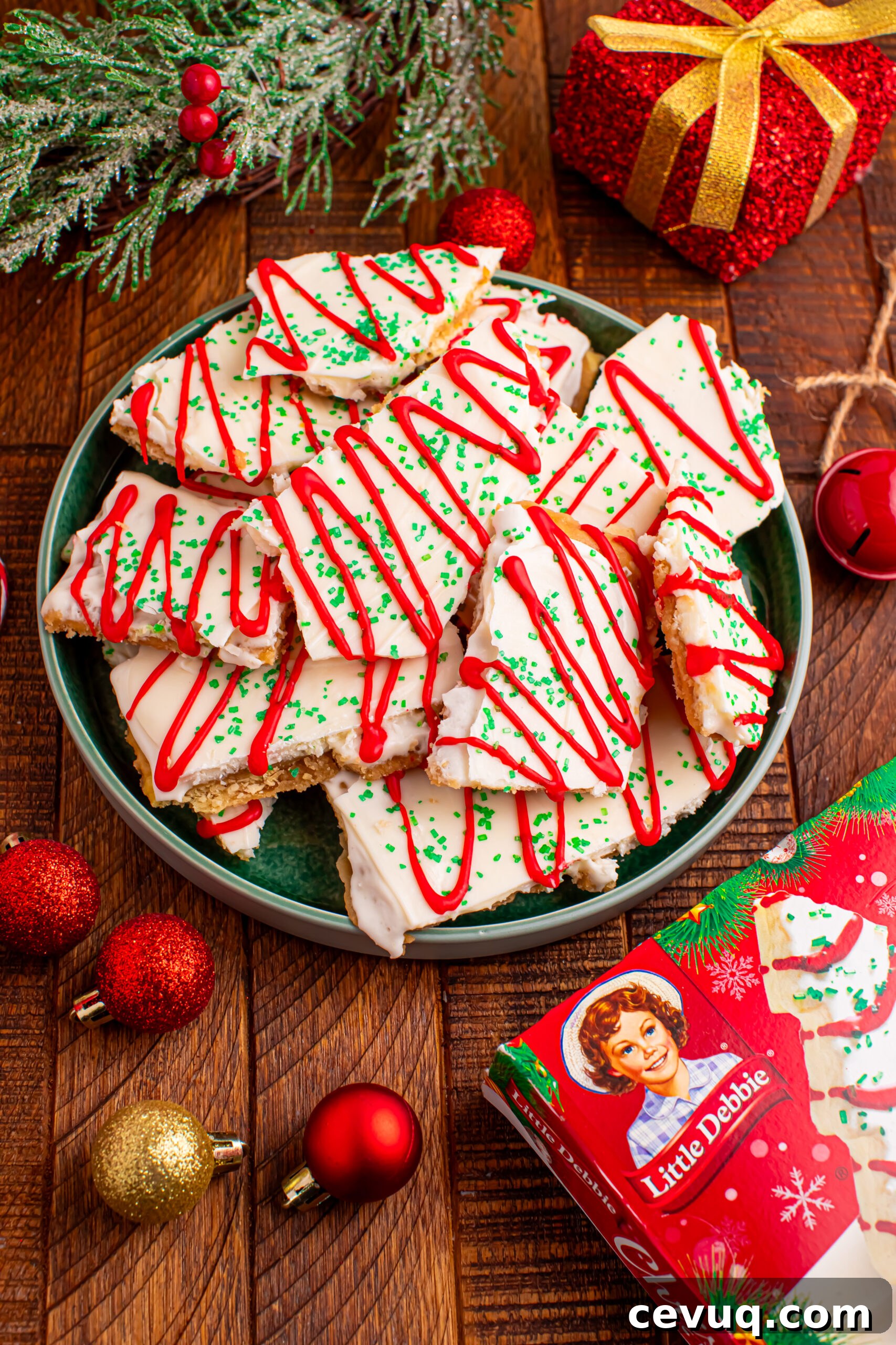 Christmas Tree Crack piled on a green serving platter on a dark wood table surrounded by christmas decorations